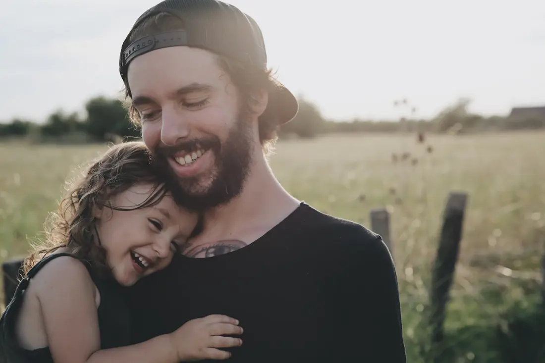 Un padre abraza a su hija al aire libre